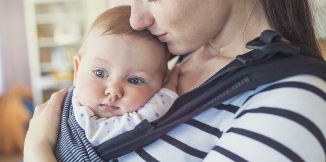 Il piccolo neonato stretto al petto della mamma Perché usare il marsupio per il neonato