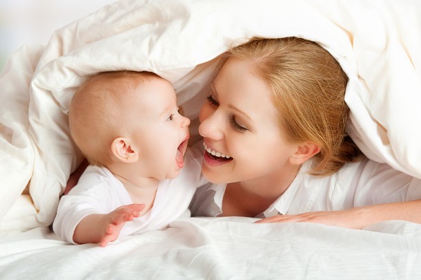 La voce della mamma sviluppa il cervello del piccolo neonato.
Mamma e neonato sono nel letto sotto le coperte. La voce della mamma sviluppa il cervello del neonato