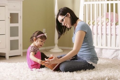 I bambini hanno bisogno di regole per crescere, oltre che di amore e affetto.
Nell'immagine ci sono una mamma e la sua bambina sedute per terra a giocare. I bambini hanno bisogno di regole per crescere, oltre che di amore